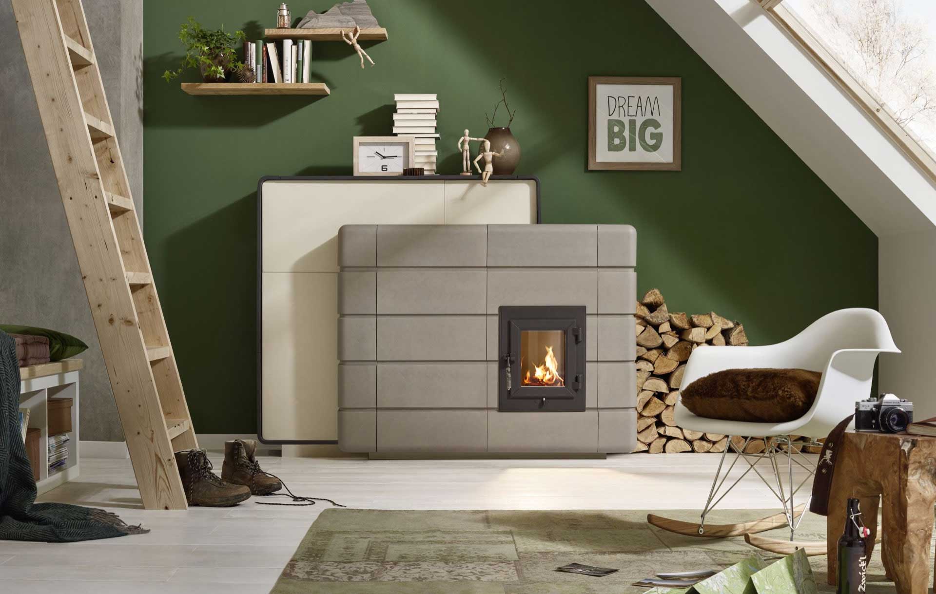 Junges Studio unterm Dach: grüne Wand mit kompakter, quaderförmiger Ofenanlage, Holzstapel, Eames-Sessel und Deko „DREAM BIG“.