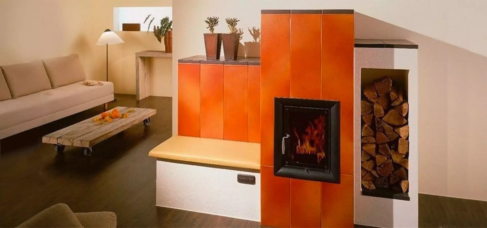 Modernes Wohnzimmer mit orange gekacheltem Kachelofen, integrierter Sitzbank und seitlicher Holzlagernische; links Sofa und niedriger Couchtisch
